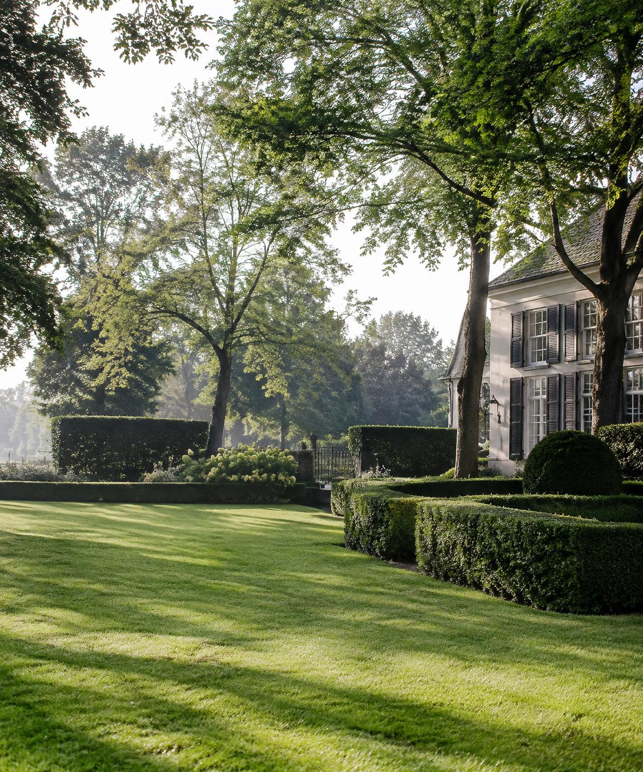 Strak onderhouden tuin met gesnoeide hagen en borders